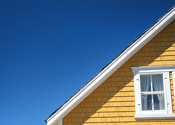A yellow house against a blue sky