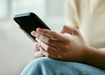 A close-up of hands holding a mobile phone