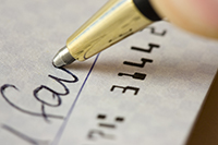 Close-up of a check being signed