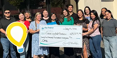 Un grupo de empleados sosteniendo un cheque gigante