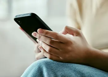 Primer plano de unas manos sosteniendo un teléfono móvil