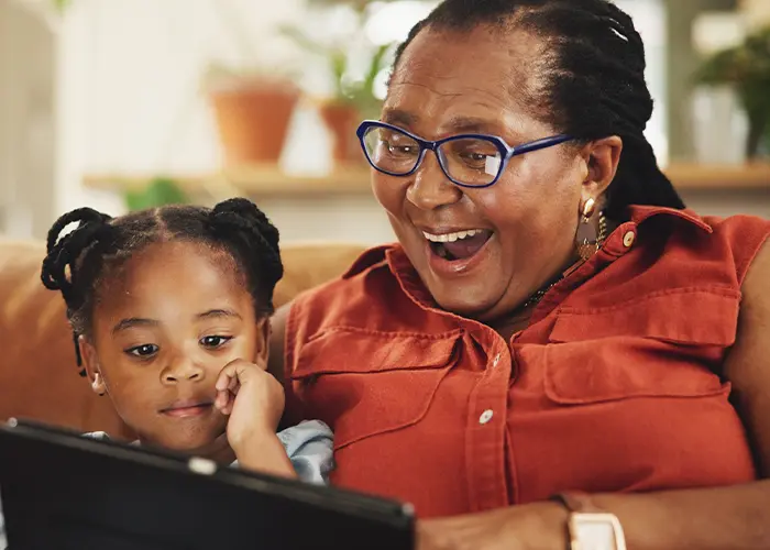 Una abuela y un nieto mirando una tableta