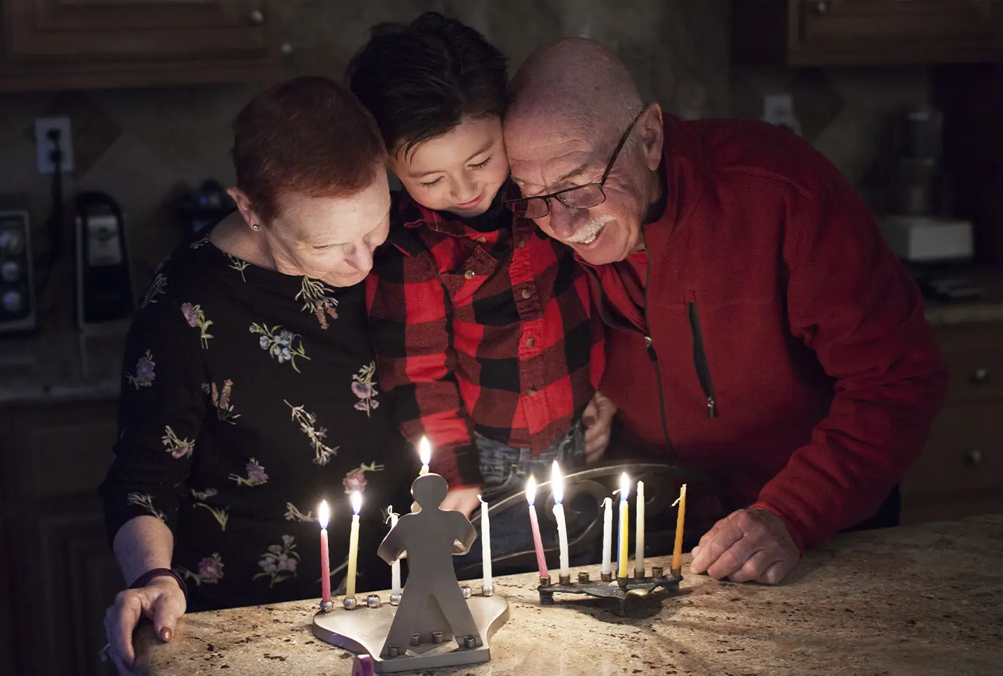 Grandparents and grandchildren lighting a menorah