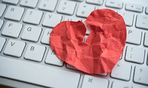 A crumpled paper heart on a keyboard