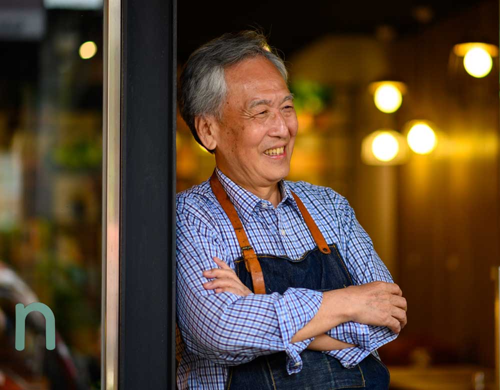 Older man leaning against doorway