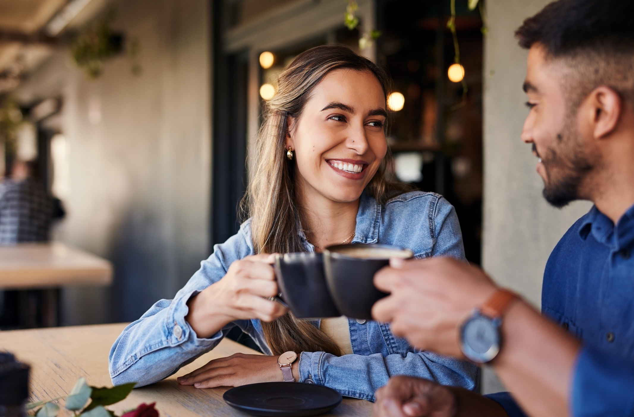 Two people clinking their coffee cups together