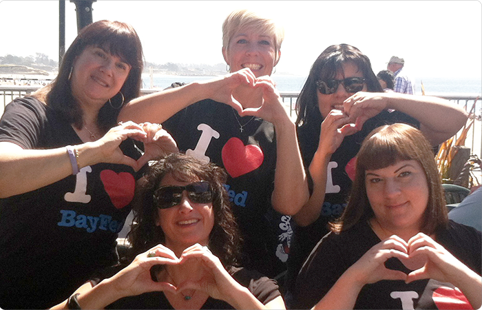 Bay Fed employees making heart shapes with their hands
