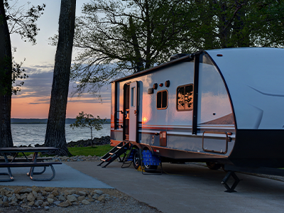 An RV parked at a lake-side camping spot