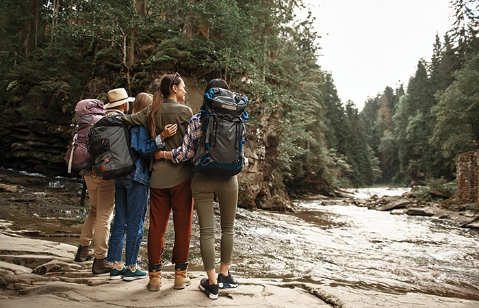 Amigos haciendo senderismo admirando el río